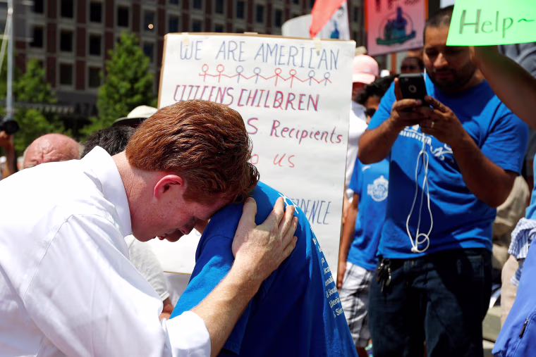 Image: U.S. Representative Joe Kennedy III (D-MA) listens to 12-year-old Brian Pineda, whose father has TPS immigration status, during the \"Families Belong Together\" rally in Boston