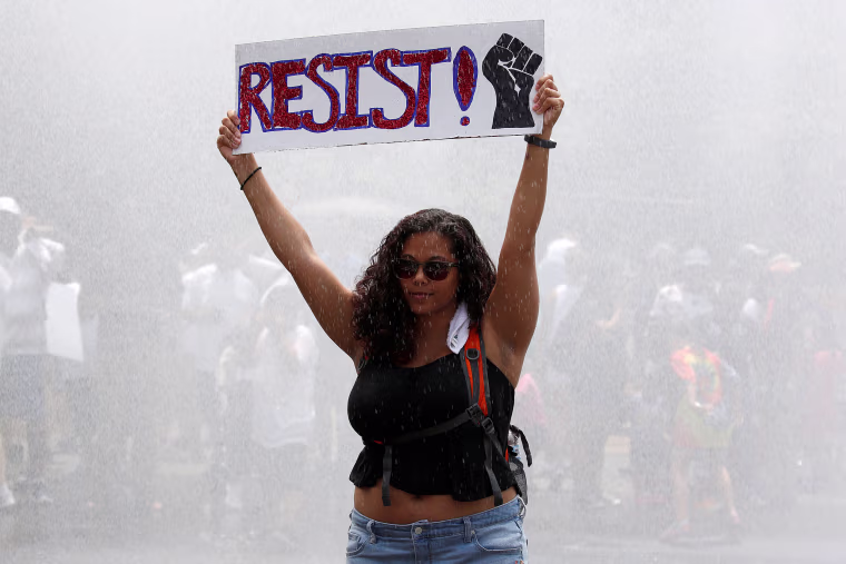 Image: An immigration activist holds up a sign during a rally by immigration activists to protest against the Trump Administration's immigration policy, outside the White House in Washington