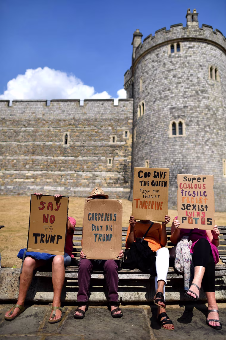 Image: Protesters against the visit of US President Donald Trump carry placards outside Windsor Castle