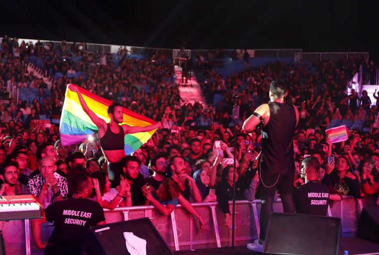 Image: A fan of Lebanese alternative rock band Mashrou' Leila holds a rainbow flag during their concert at the Ehdeniyat International Festival in Ehden town