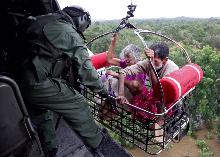 Image: People are airlifted by the Indian Navy soldiers during a rescue operation at a flooded area in the southern state of Kerala