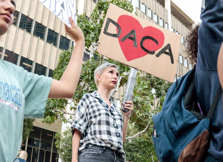 Image: Allison Agsten of Los Angeles stands with supporters of the Deferred Action for Childhood Arrivals (DACA) program during a rally outside the Edward R. Roybal Federal Building in Los Angeles, California