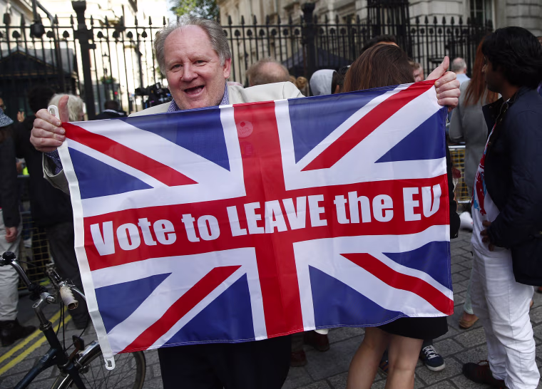 Image: A vote leave supporter holds a Union flag, following the result of the EU referendum, outside Downing Street in London