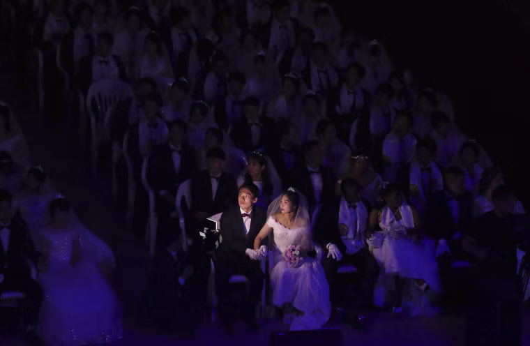 Image: A couple watches a screen during a mass wedding at the Cheong Shim Peace World Center