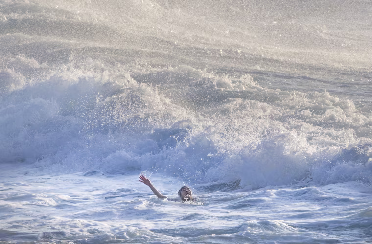 Image: A woman screams for help as she is caught in a rip tide before being rescued