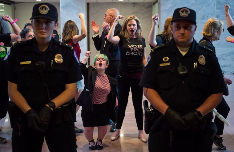 Police look on as protesters are arrested in the Hart Senate Office Building during a rally against Supreme Court nominee Brett Kavanaugh on Capitol Hill on Oct. 4, 2018.