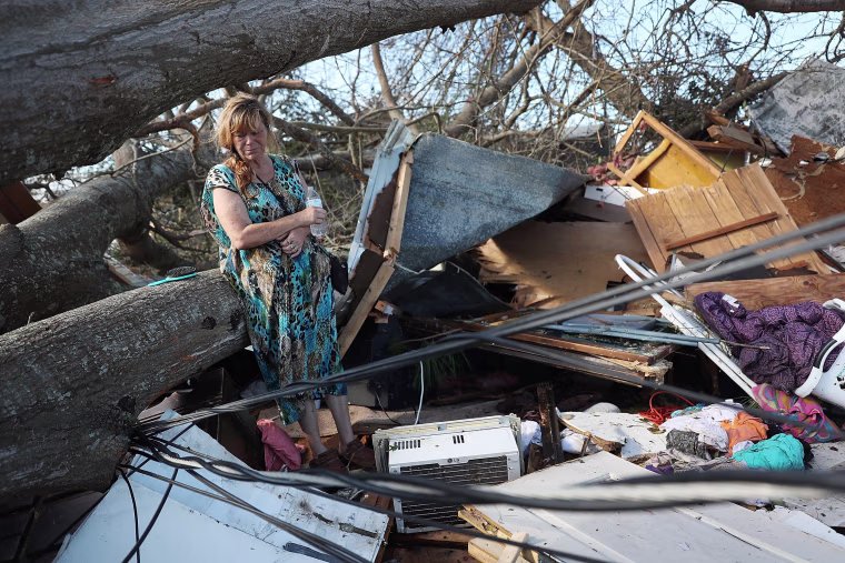 Kathy Coy stands among what is left of her home after Hurricane Michael destroyed it
