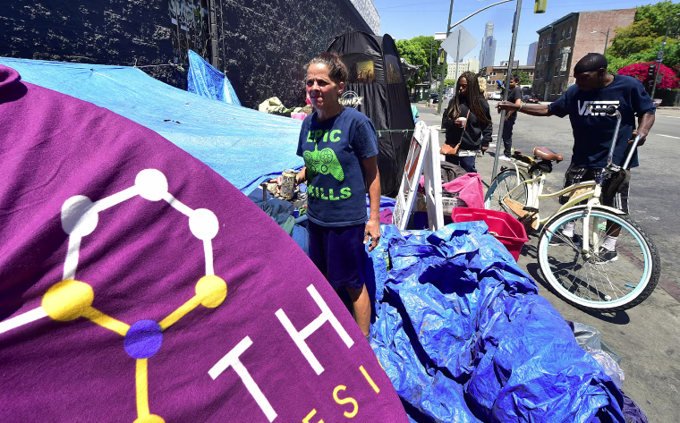 Homeless since August 2016, Tina Marie Van Tasil holds a can of beer while standing in front of her tent near Skid Row in downtown Los Angeles on June 20, 2017.