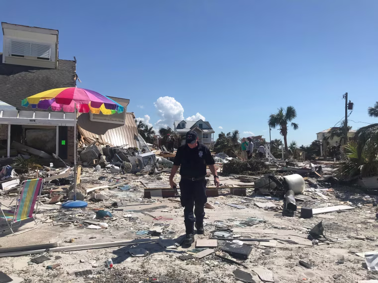 A FEMA officer from the Indiana Task Force walks over debris near command central.