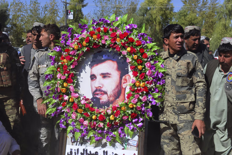 Image: Military personnel hold a photo of Gen. Abdul Raziq, Kandahar police chief, who was killed by a guard, during his burial ceremony in Kandahar