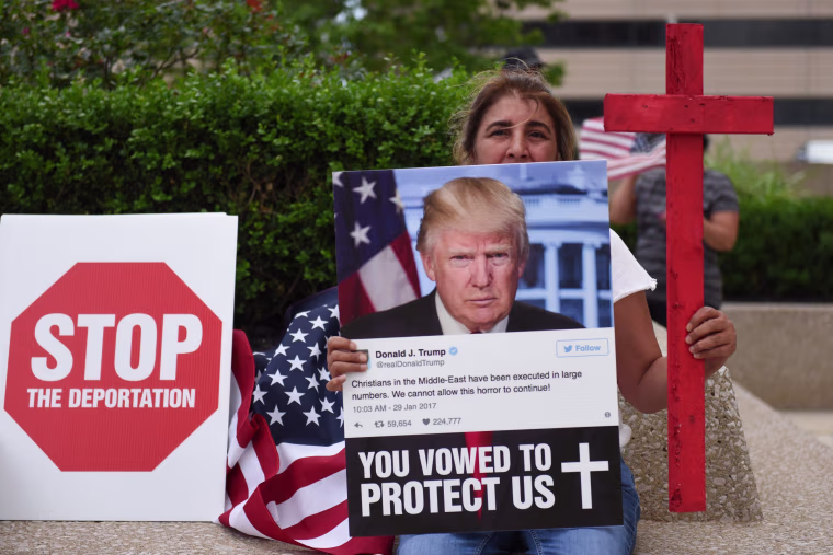 Amal Hana, of Warren, Mich., holds a photo of Donald Trump on June 16, 2017, outside the Patrick V. McNamara Federal Building during a protest in Detroit. Hana joined hundreds others to protest the recent ICE raids in which more than 100 Iraqi nationals in Metro Detroit were detained.