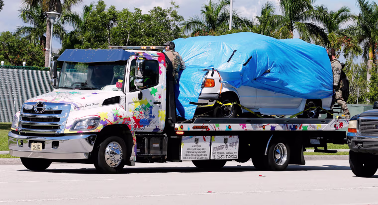 A white van seized during an investigation into a series of parcel bombs is towed into FBI headquarters in Miramar