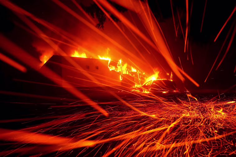 Embers blow as the fire engulfs a KFC restaurant in Paradise, California.