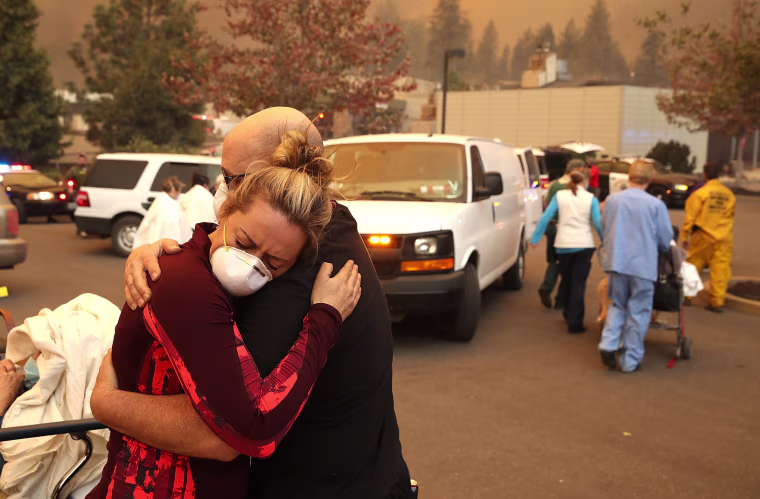 A hospital worker embraces her co-worker as they evacuate patients from the Feather River Hospital in Paradise, California, on Nov. 8, 2018.