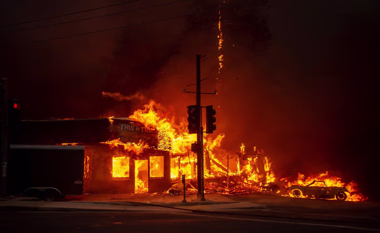 The rapidly spreading fire burns through a store. Gov.-elect Gavin Newsom called a state of emergency in Butte County.