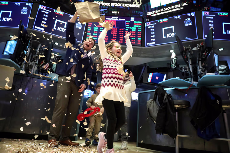 Image: Trader Ben Tuchman dumps paper during a traditional bring-your-kids-to-work day on the floor at the NYSE in New York