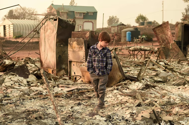 Image: Jacob Saylors, 11, walks through the burned remains of his home in Paradise, California on Nov. 18. The family lost a home in the same spot to a fire 10 years prior.