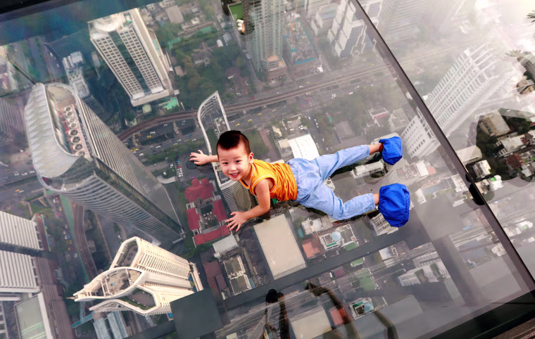 Image: A boy plays on the glass at Thailand's first skywalk in Bangkok