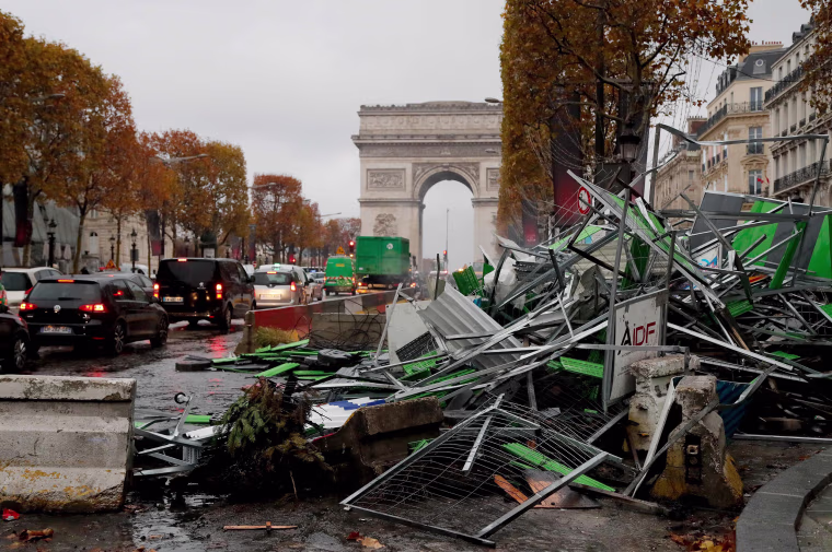 Image: Broken barriers litter the Champs-Elysees near the Arc de Triomphe