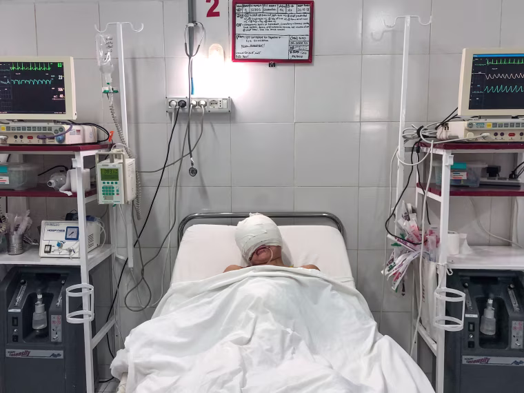 Image: Ehsanullah lies in hospital, his face and head bandaged