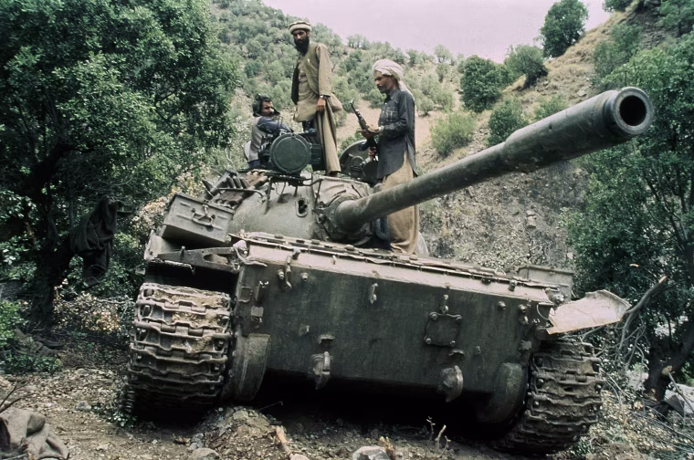 Image: Mujahedeen sit on a captured Soviet tank in Afghanistan in 1987.