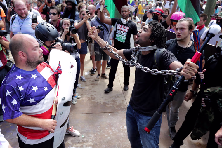 White nationalists, neo-Nazis and members of the \"alt-right\" exchange insults with counter-protesters as they attempt to guard the entrance to Lee Park during the \"Unite the Right\" rally on Aug. 12, 2017 in Charlottesville, Virginia.