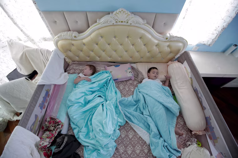 Image: An Zhizhong and An Zhiya sleep at home in Shenzhen, China, on Sept. 17, 2018.