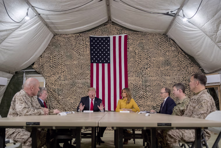 Image: President Donald Trump and Melania Trump meet with National Security Adviser John Bolton, U.S. Ambassador to Iraq Doug Silliman, and military leadership at Al Asad Air Base.