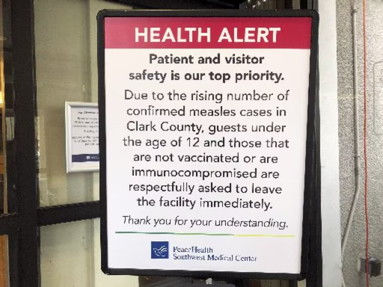 A sign prohibiting all children under 12 and unvaccinated adults stands at the entrance to PeaceHealth Southwest Medical Center in Vancouver, Wash., Friday, Jan. 25, 2019. Washington Gov. Jay Inslee declared a statewide public health emergency Friday as confirmed measles cases rose to 30, with nine more suspected.