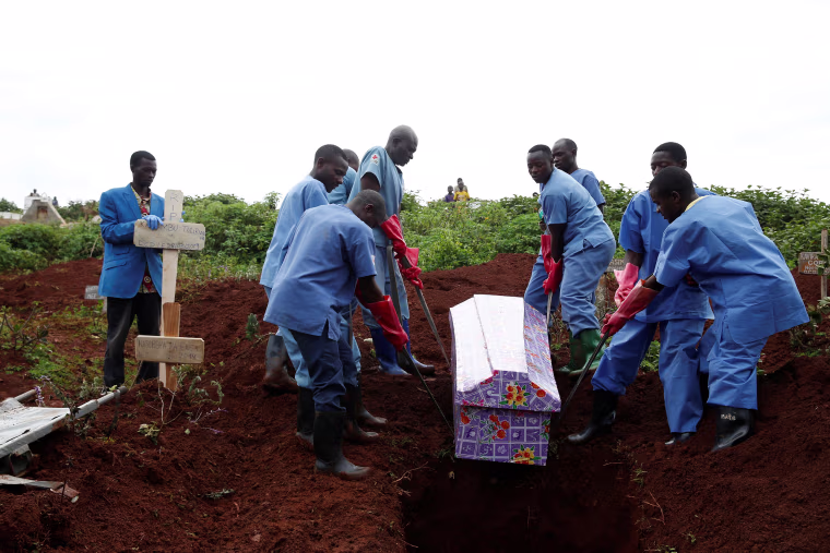 Image: Red Cross workers carry the coffin of woman who was killed by Ebola