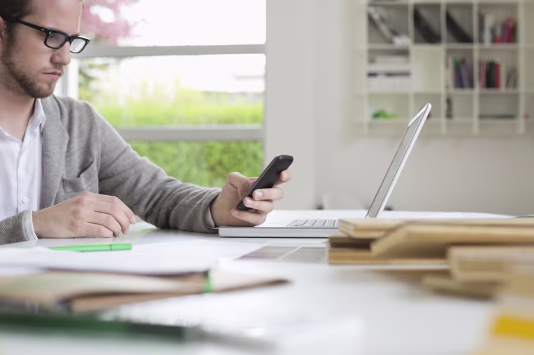 Interior designer using a mobile phone in the office