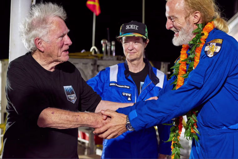 Don Walsh, left, and Victor Vescovo shake hands aboard the ship, DSSV Pressure Drop.