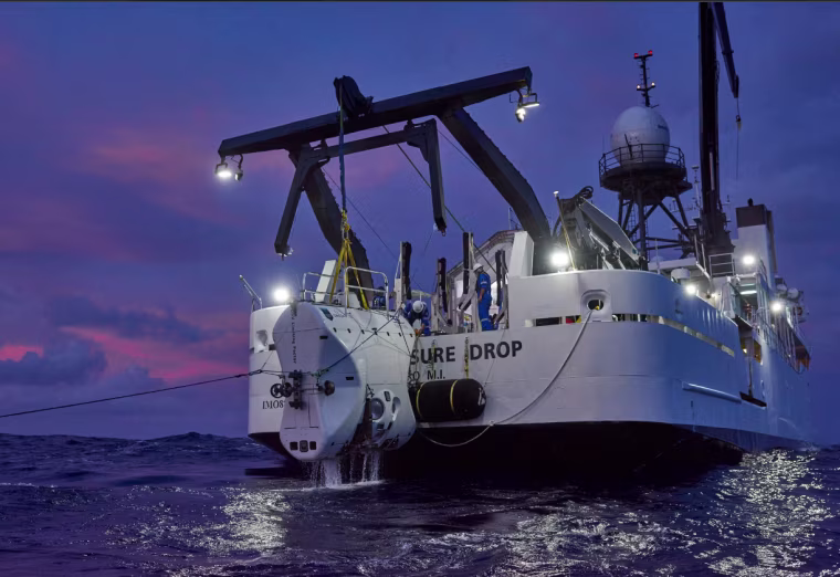 The submersible returns from the depths of the Mariana Trench, is pulled up onto the ship, the DSSV Pressure Drop.