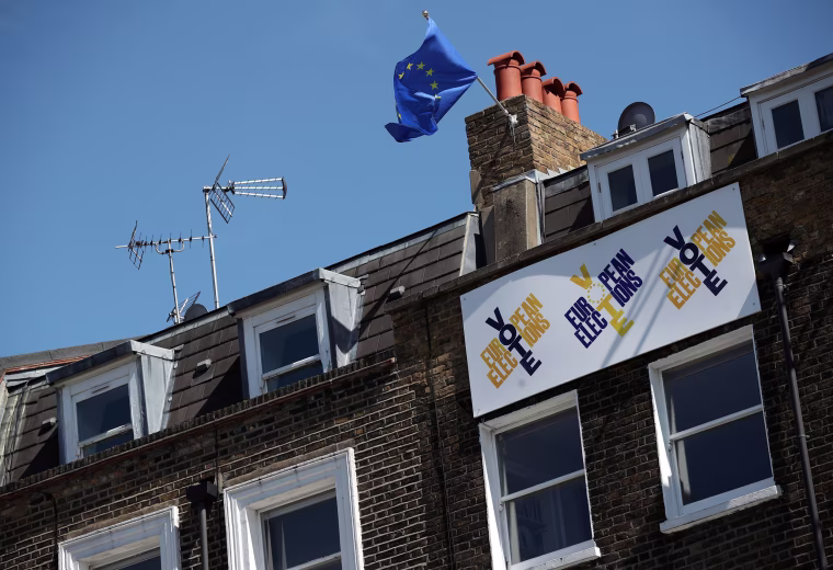 Image: A European Union flag flies and a Vote European Election sign hangs from a house in south London