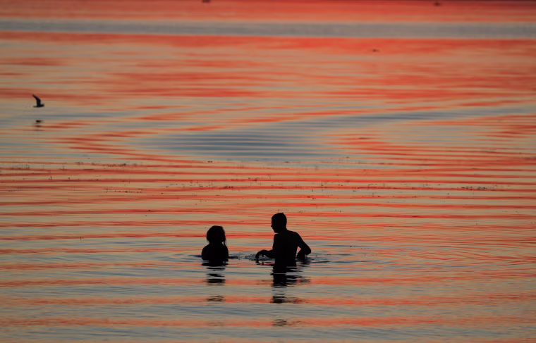 Image: People enjoy sunset in a lake on the outskirts of Minsk