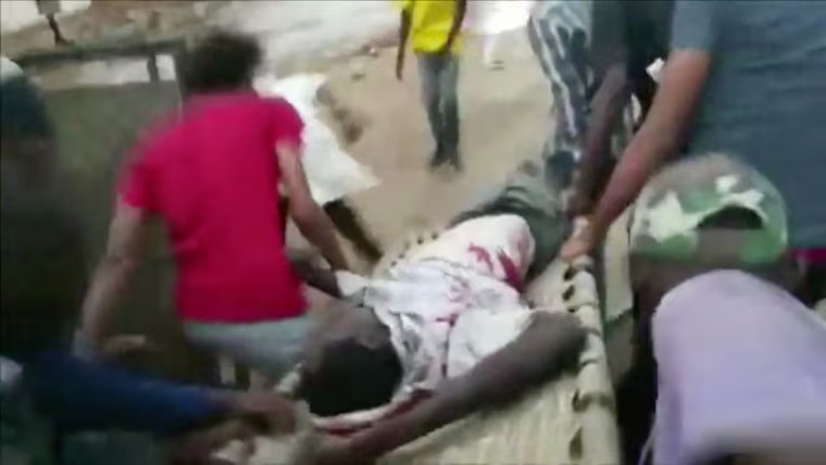 Image: An injured man is carried on a stretcher during protests in Khartoum