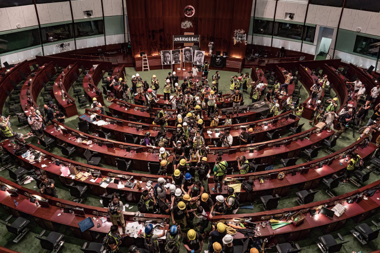 Image: Protesters leave the legislative chamber