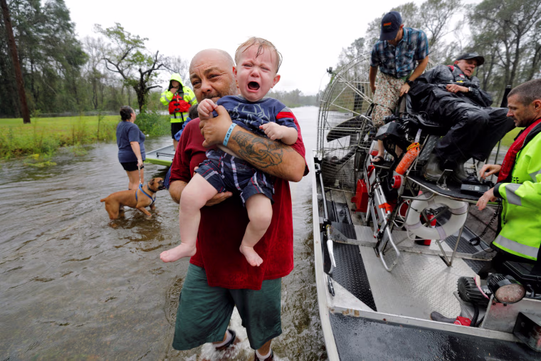 Image: Oliver Kelly, 1 year old, cries as he is carried off the sheriff's airboat during his rescue from rising flood waters in the aftermath of Hurricane Florence in Leland, North Carolina