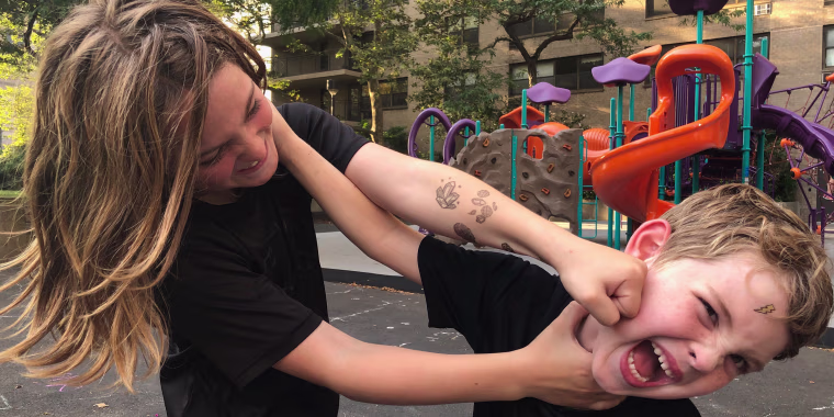 These are Rebecca Dube's sons. They're just play-fighting! They're both having fun and no children were harmed in the making of this photo. Of course 30 seconds later they were fighting for real and someone started crying.