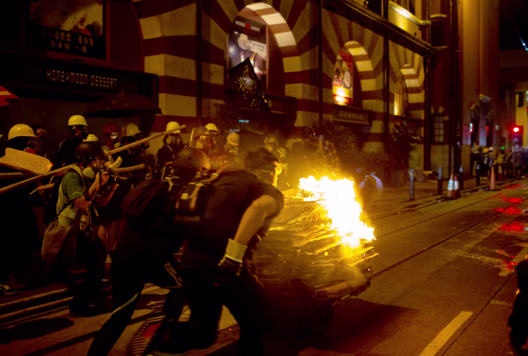 Image: Protesters push a burning cart towards police during a demonstration in the Sheung Wan district of Hong Kong on July 28, 2019.