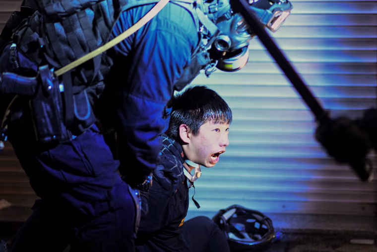 Image: A pro-democracy protester is held by police outside Tsim Sha Tsui Police station during a demonstration against the controversial extradition bill in Hong Kong