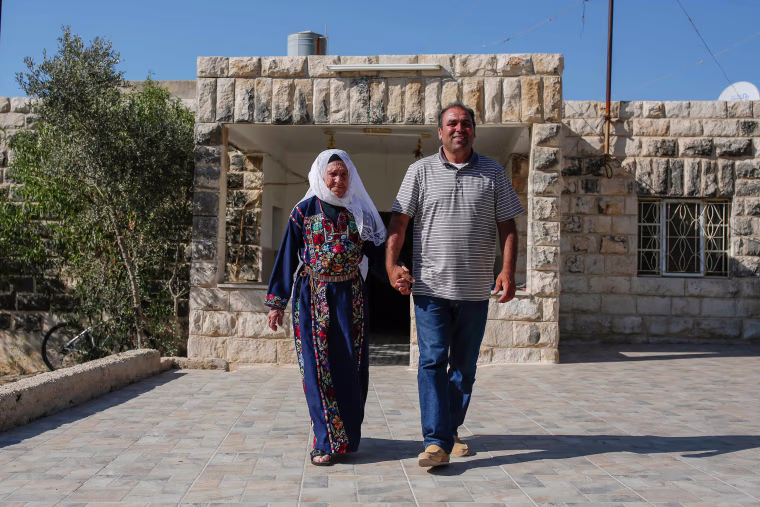 Image: Muftia Tlaib, the maternal grandmother of Congresswoman Rashida, walk with her son Bassam outside their home in the village of Beit Ur al-Fauqa, in the occupied West Bank