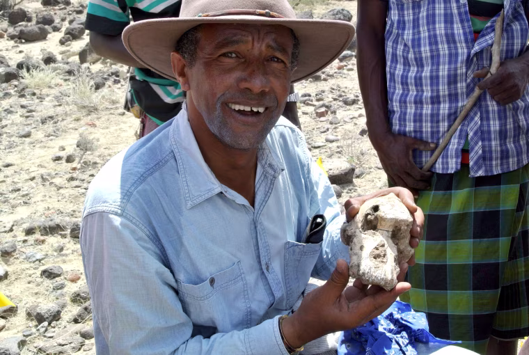 Image: Yohannes Haile-Selassie posing with a fragment of Australopithecus skull in Ethiopia.