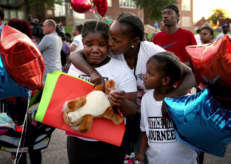 Image: Shardae Edmondson, 11, is consoled by her mother, Sharonda Edmondson, and sister Zha'lea Thompson, 7, during a vigil for murdered children in St. Louis held at Herzog Elementary School in the city Aug. 28, 2019. Shardae's and Zha'lea's sister Jurne