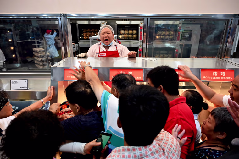 Image: People try to buy roast chicken at the opening of the first Costco in Shanghai, China, on Aug. 27. 2019.