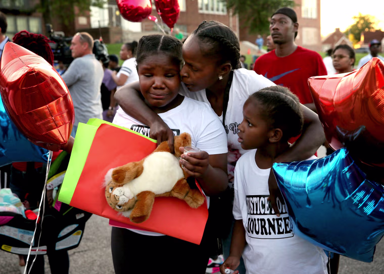 Image: Shardae Edmondson, 11, is consoled by her mother, Sharonda Edmondson, and sister Zha'lea Thompson, 7, during a vigil for murdered children in St. Louis held at Herzog Elementary School in the city Aug. 28, 2019. Shardae's and Zha'lea's sister Jurne