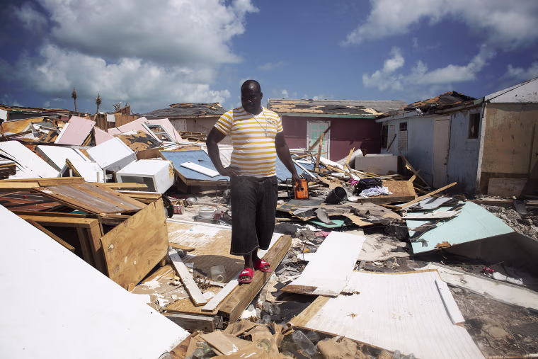 Kenson Accius observes the site where his friend's body was found minutes earlier in the Mudd neighborhood on Abaco Island, Bahamas.