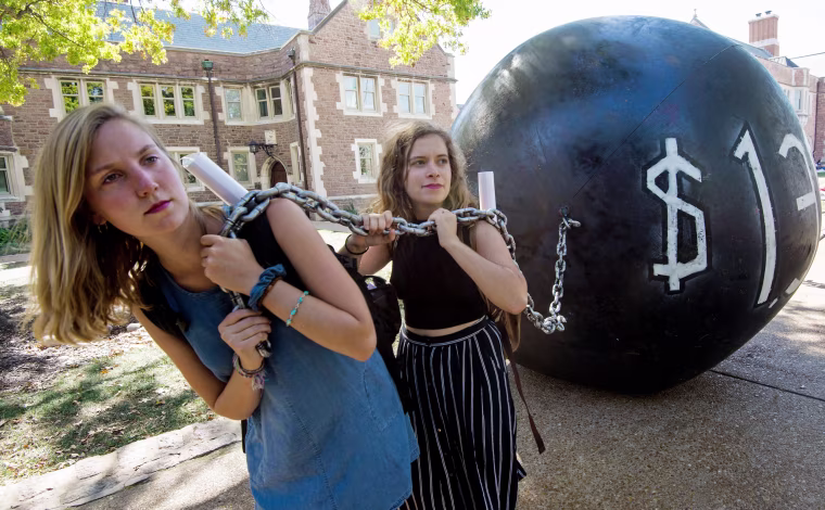 Image: Students pull a mock "ball and chain" representing the outstanding student debt at Washington University