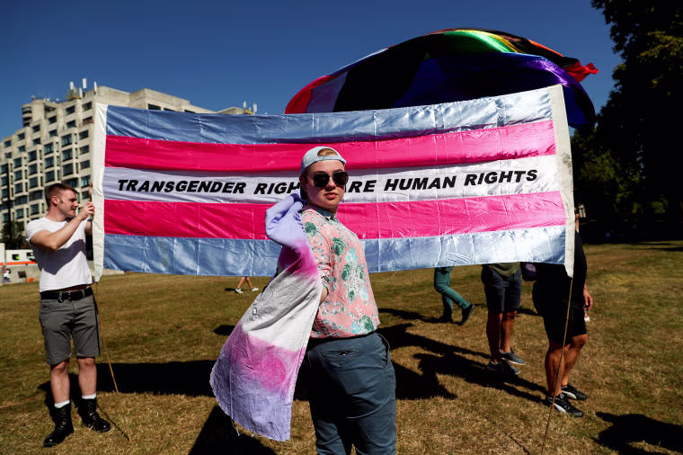 Image: A protester poses in front of a trans flag at the Trans Pride March in London on Sept. 14, 2019.