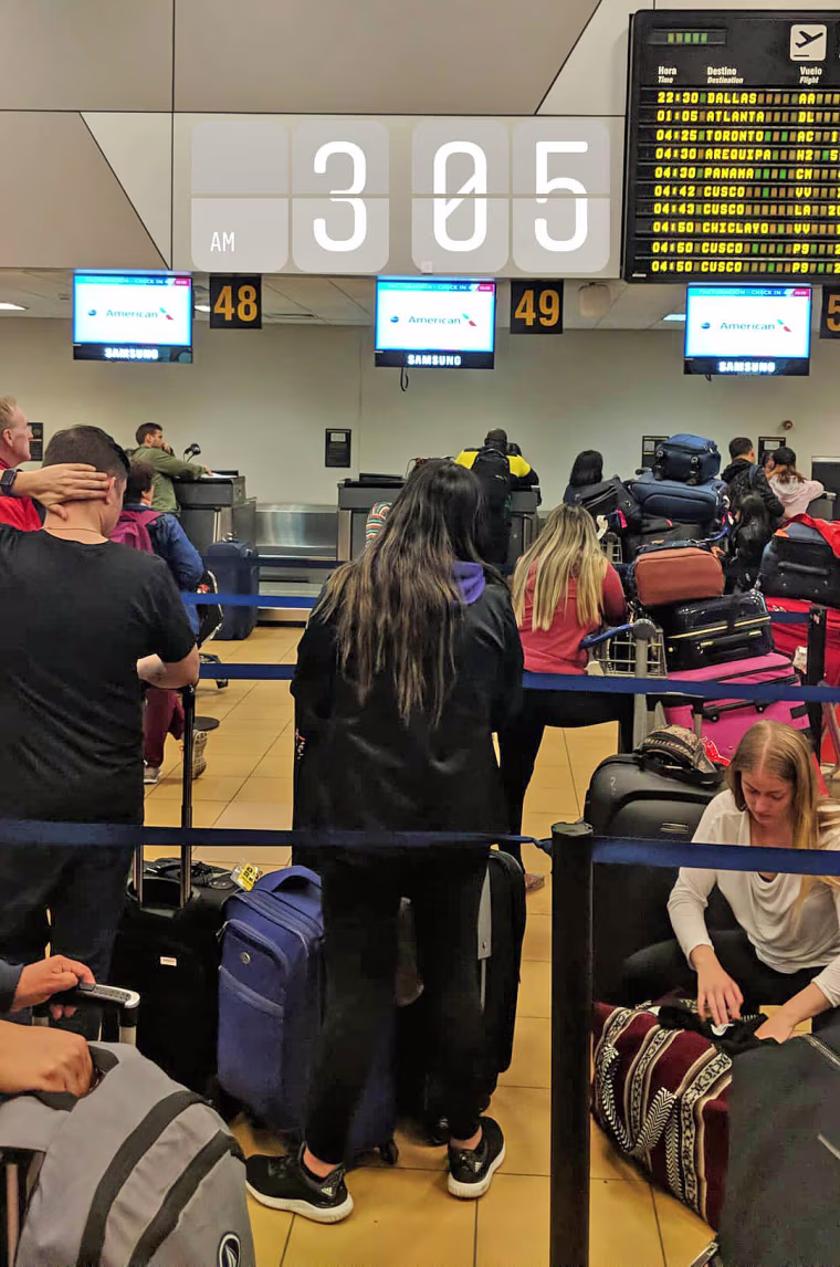 Passengers wait in line for food and hotel vouchers in the early morning hours of September 11 after their plane waited at the gate for two and a half hours.